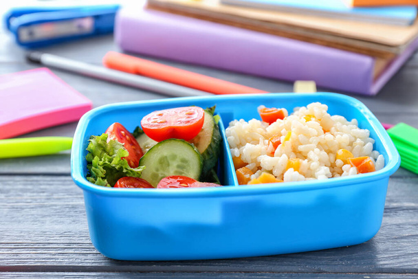 Школьный обеденный стол с вкусной едой на деревянном фоне
 - Фото, изображение
