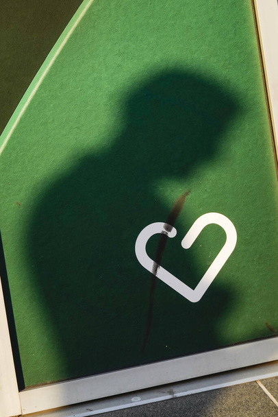 Стокгольм, Швеция 9 марта 2020 Символ сердца на стене совпадает с тенью человека
. - Фото, изображение