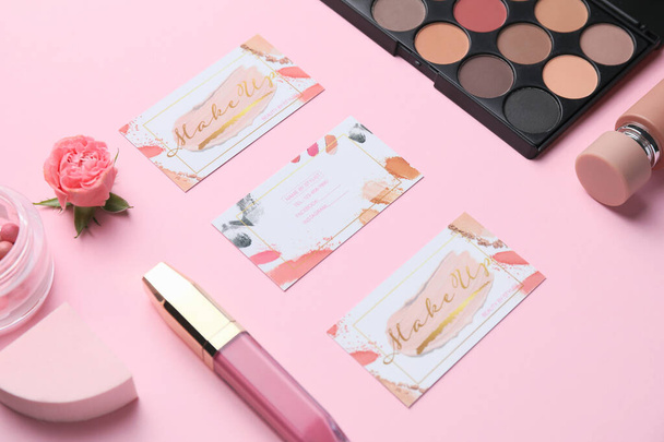 Decorative cosmetics with business cards of makeup artist on color background - Photo, Image