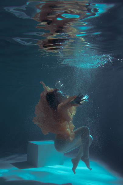Bella ragazza nuota sott'acqua in un vestito giallo. 2020 Capodanno tendenza Aqua Mente e fatom blu e lava lussureggiante. Sirenetta subacquea. Modello adatto alla pubblicità
 - Foto, immagini