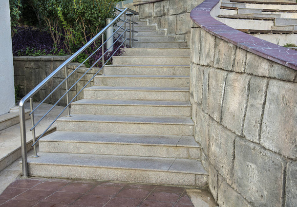 Kamienne schody na zewnątrz. Kamienne stopnie starych schodów ze stali nierdzewnej - Zdjęcie, obraz