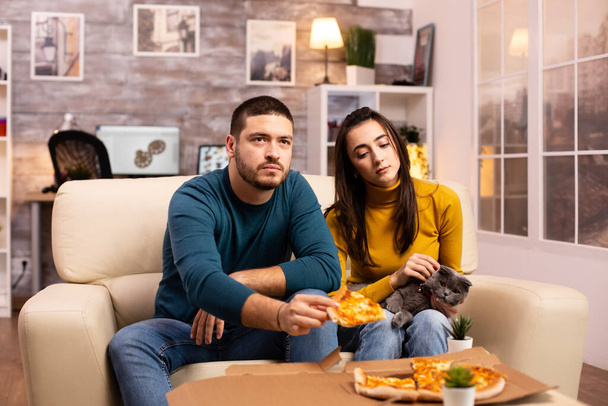 wunderschöne junge Paar Pizza essen, während Fernsehen - Foto, Bild