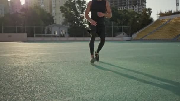 A concentrated young sportsman is having a break while running at the stadium - Filmmaterial, Video
