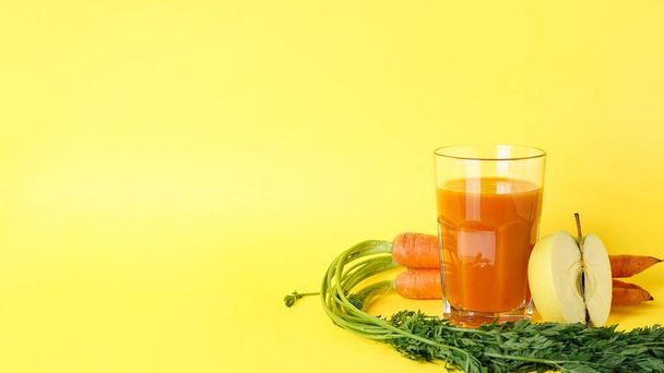 Fresh carrot juice and ripe carrots & apple on a yellow background. Space for text. - Φωτογραφία, εικόνα