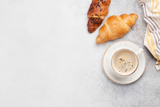 Snídaně s kávou a croissantem. Pohled shora na kamenný stůl. Byt ležel s kopírovacím prostorem - Fotografie, Obrázek