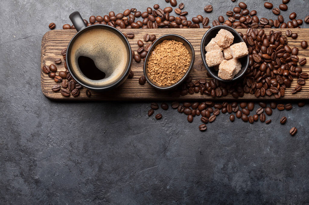Coffee cup, sugar and roasted beans on dark stone table. Top view with copy space. Flat lay - Photo, Image