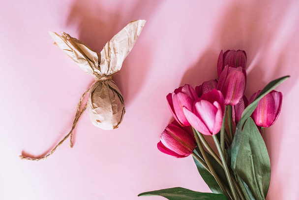 Huevo de Pascua en papel artesanal con tulipanes rosados
 - Foto, Imagen