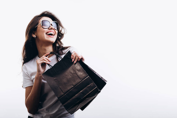 Smějící se krásná mladá žena těší její módní nákupy - Fotografie, Obrázek