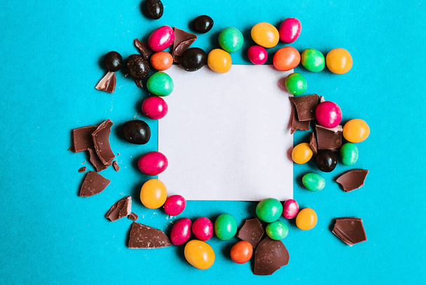 Easter composition with chocolate eggs on a colored blue background, place for text. - Foto, Bild