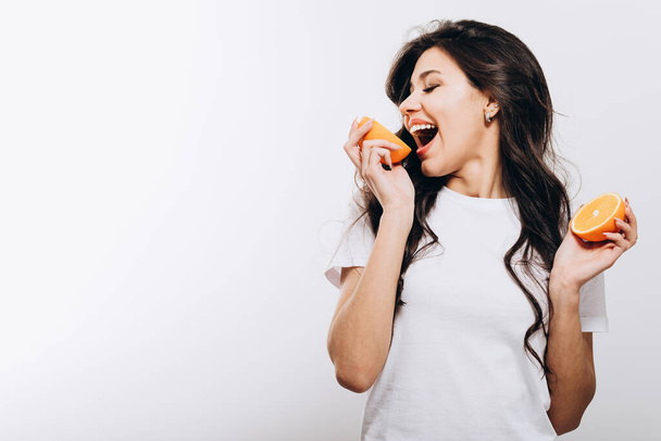 Morena menina jogando tolo com metades de laranja
 - Foto, Imagem