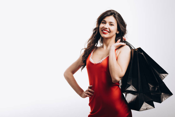 lindo glamour joven morena posando con negro bolsas de compras
 - Foto, imagen