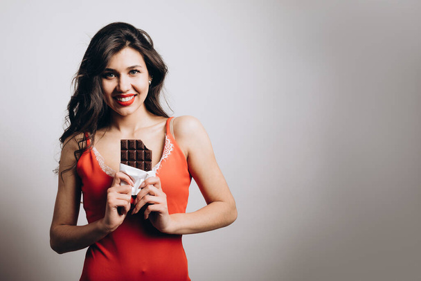 Attractive Young Brunette Woman Posing With a Chocolate Bar - Foto, imagen