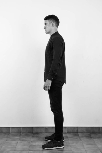 Estudio plano de joven hombre de negocios guapo sobre fondo blanco en blanco y negro - Foto, imagen