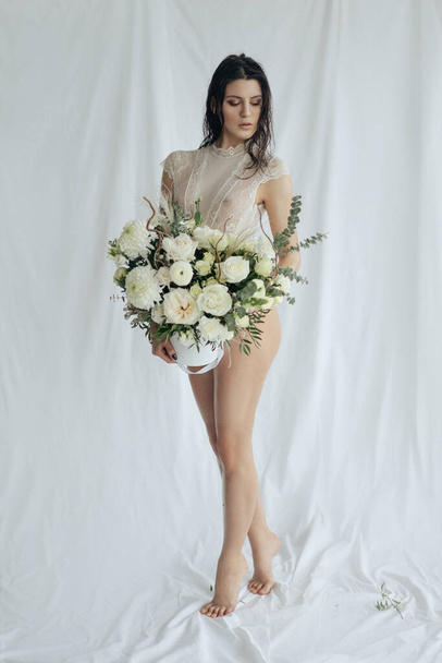 Girl with white roses and amaryllis on a white background - Fotoğraf, Görsel