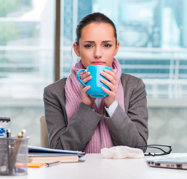 Young businesswoman sick in the office - Foto, afbeelding