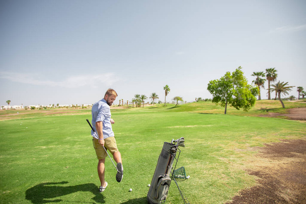 A man on a golf course examines the equipment and prepares for a sporting event at the golf club - Foto, Imagen