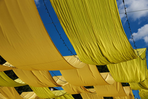 Большие панели из жёлтой ткани вытянуты над землей. Фон
 - Фото, изображение