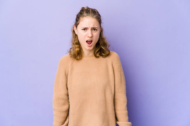 Young caucasian woman on purple background shouting very angry, rage concept, frustrated. - Photo, Image