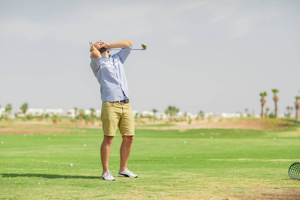 Ένας άντρας παίζει γκολφ και περνάει καλά το Σαββατοκύριακο. - Φωτογραφία, εικόνα