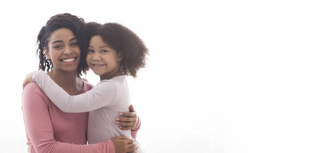 Madres Amor. retrato de feliz afro mujer abrazando con poco hija
 - Foto, Imagen
