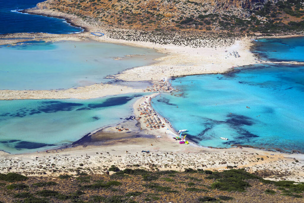 Balos lagoon on Crete island, Greece. Tourists relax in crystal clear water of Balos beach. - Фото, изображение