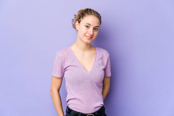 Young caucasian woman on purple background happy, smiling and cheerful. - Photo, Image