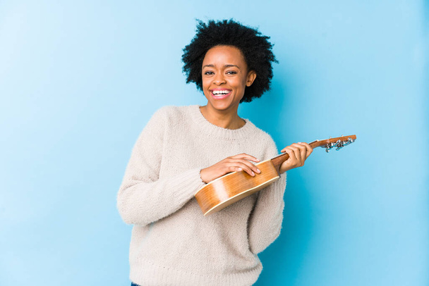Young african american woman playing ukelele - Fotografie, Obrázek