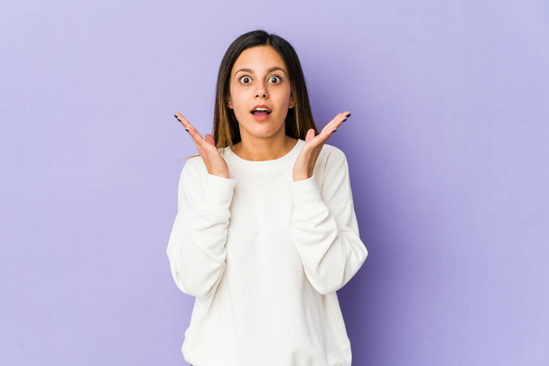 Young woman isolated on purple background surprised and shocked. - Fotoğraf, Görsel