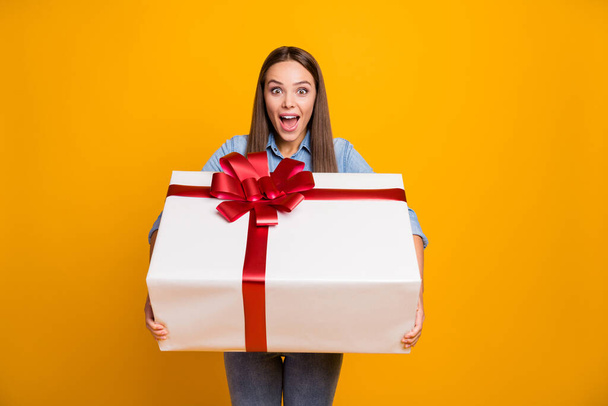 Portrait of crazy excited girl receive unbelievable big long waited desire gift box impressed scream wow omg wear good look outfit isolated over bright color background - Foto, Bild