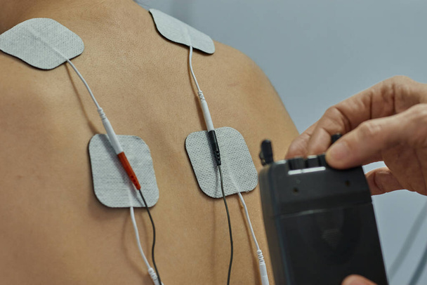 Electro stimulation en physiothérapie pour une jeune femme. Examen médical à l'épaule dans un centre de physiothérapie. Thérapie des adolescents
 - Photo, image