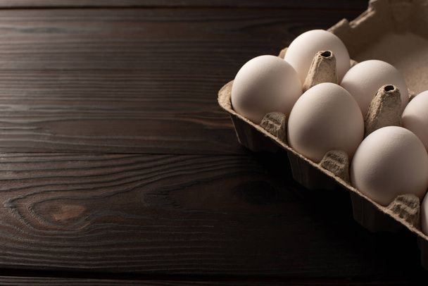 white chicken eggs in egg tray on dark wooden background - Foto, Imagem