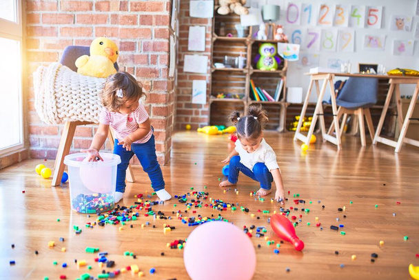 Adorable toddlers playing with building blocks toy at kindergarten - Photo, Image