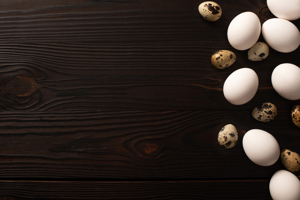 vista superior de huevos de pollo y codorniz en la superficie de madera oscura
 - Foto, Imagen