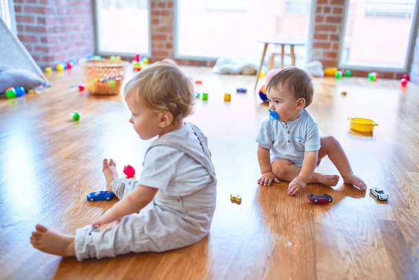 Mooie peuters spelen rond veel speelgoed op de kleuterschool - Foto, afbeelding