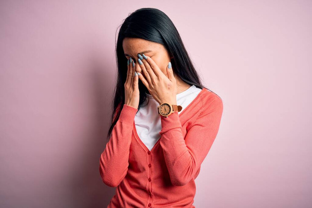 Young beautiful chinese woman wearing casual sweater over isolated pink background rubbing eyes for fatigue and headache, sleepy and tired expression. Vision problem - Foto, Imagem