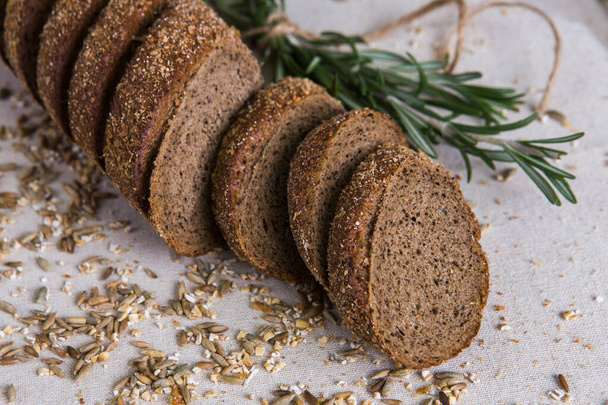 Whole- grain rye baguette on a tree with wheat grains. Dietary product of proper nutrition - Photo, image