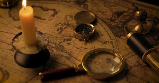 exploratieconcept - antieke objecten op oude wereldkaart in kaarslicht. dolly schot - Video