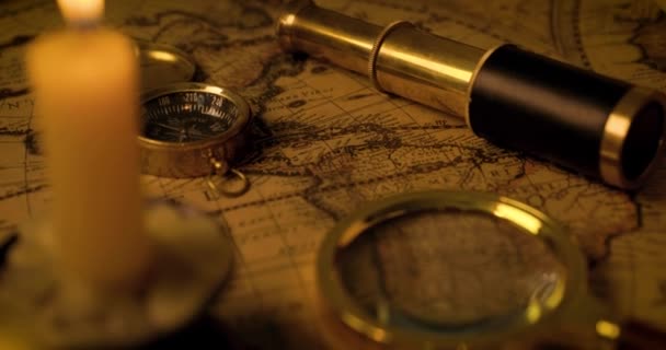 exploratieconcept - antieke objecten op oude wereldkaart in kaarslicht. dolly schot - Video