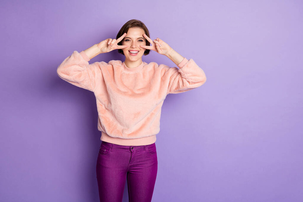 Portrait of cheerful positive funky youth girl make v-sign enjoy winter holidays feel satisfied emotions wear good looking clothes isolated over purple color background - Foto, afbeelding