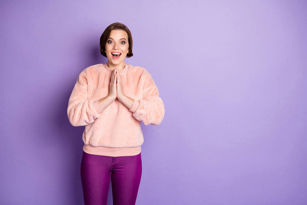 Portrait of amazed girl hear wonderful novelty she get dream surprise scream wow omg unbelievable put hands palms together wear casual style clothing isolated over purple color background - Foto, imagen