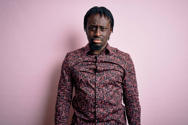 Νεαρός όμορφος Αφροαμερικάνος που φοράει casual πουκάμισο στέκεται πάνω από ροζ φόντο μελαγχολικός και ανησυχεί για την αγωνία, κλαίει θυμωμένος και φοβισμένος. Θλιβερή έκφραση. - Φωτογραφία, εικόνα
