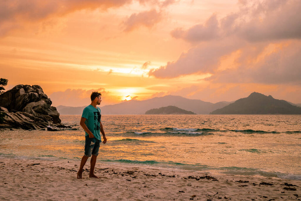 La Digue Seychelles, giovane uomo in abiti casual sulla spiaggia di Anse Source dArgent, LA Digue Seychelles, vicino a Praslin e Mahe Island
 - Foto, immagini