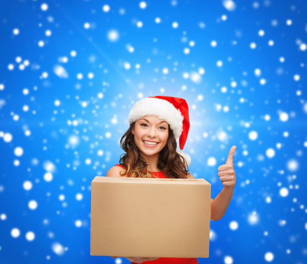 Smiling woman in santa helper hat with parcel box - 写真・画像
