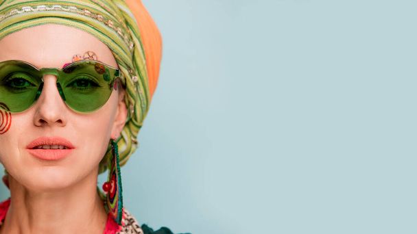 Beautiful woman with a turban on her head, fashion earrings and bracelets. Africa style woman concept - 写真・画像
