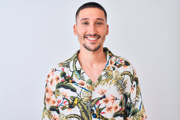 Young handsome man wearing Hawaiian summer shirt over isolated background with a happy and cool smile on face. Lucky person. - Fotografie, Obrázek
