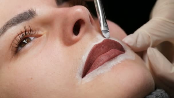Mikroplu patinaj, mikro pigmentasyon dudaklar güzellik salonunda çalışır. Dudakları çizilmiş ve kalemle boyanmış bir kadın, yarı kalıcı makyaja hazırlanıyor. - Video, Çekim