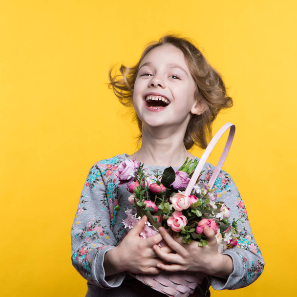 Little smile girl with flowers in basket. - Φωτογραφία, εικόνα