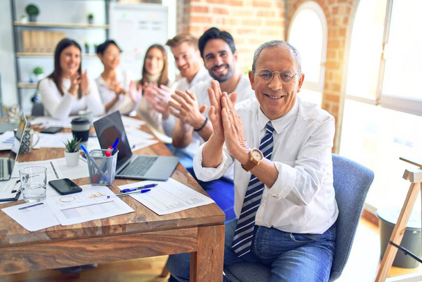 Grupo de empresários sorrindo feliz e confiante. Trabalhando em conjunto com sorriso no rosto olhando para a câmera aplaudindo no escritório - Foto, Imagem