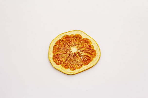 Dried single slice of grapefruit isolated on white background. Healthy eating concept, close up - Photo, Image