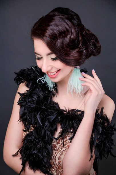 Portrait of happy brunette beautiful woman in boa from ostrich feathers . 20's years. Vertycal photo - Fotografie, Obrázek